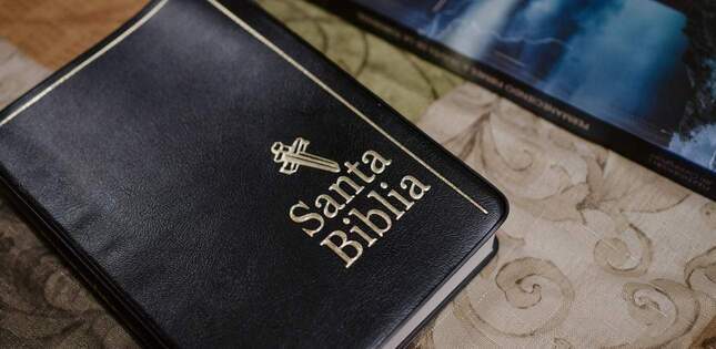 Une bible en espagnol est posée sur une table, avec le titre « Santa Biblia » visible sur la couverture.