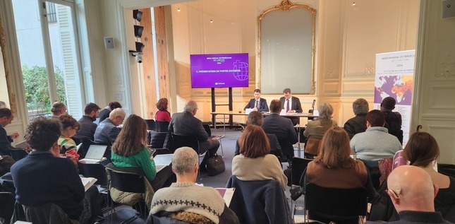 Des personnes sont assises et écoutent une présentation lors d’une conférence, face à des intervenants et un écran affichant l’Index mondial de persécution des chrétiens.