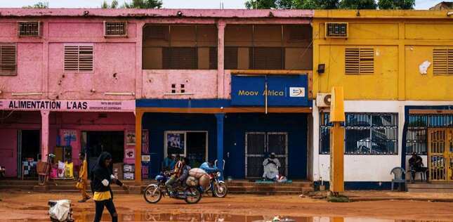 Façades colorées de commerces le long d’une rue animée.
