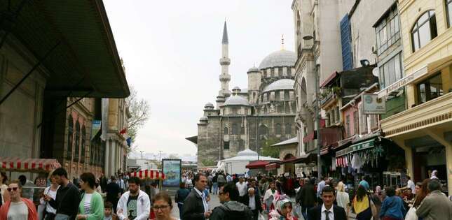 Vue d’une rue animée d’Istanbul avec une mosquée historique au centre.