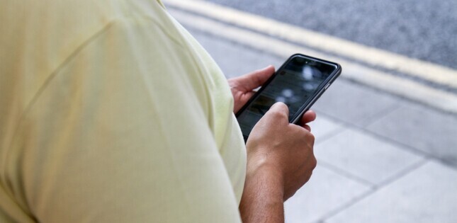 Vue d’une personne consultant son téléphone portable dans un espace public.
