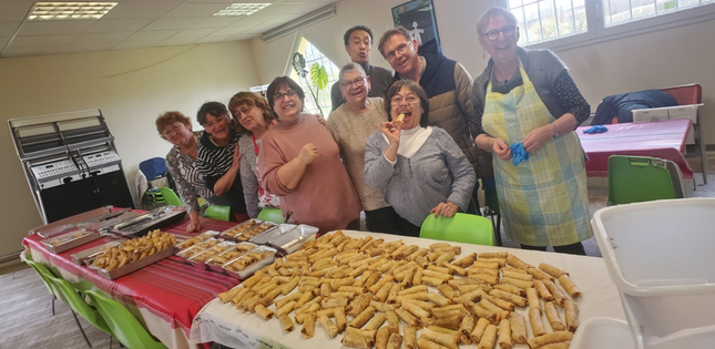 Vue d’un groupe de personnes réunies autour d’une table couverte de nems.