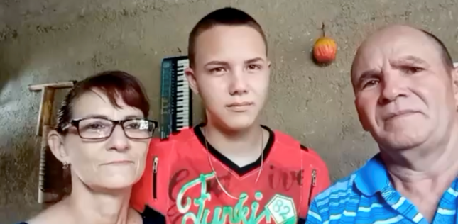Portrait de Jonathan Muir Burgos entouré de ses parents, après sa libération de prison.